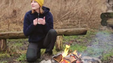 Young woman outdoors in shelter cutting wood