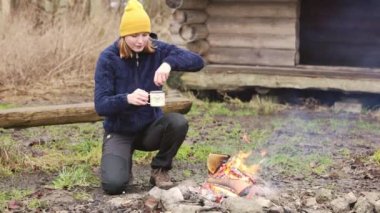 Young woman outdoors in shelter cutting wood