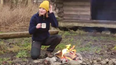 Young woman outdoors in shelter cutting wood