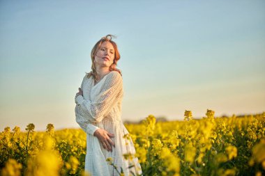 Rap sahasında beyaz elbiseli kızıl saçlı kız.