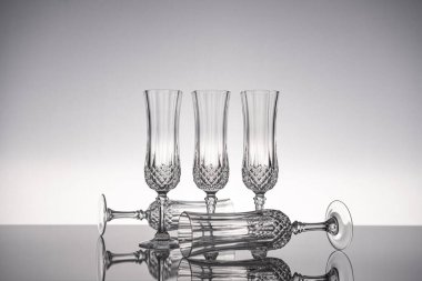 Cam kristal kadehleri kes şampanya flütü, gri arka planlı, parlak gri yüzeyde izole edilmiş..