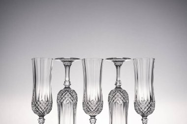 Cam kristal kadehleri kes şampanya flütü, gri arka planlı, parlak gri yüzeyde izole edilmiş..