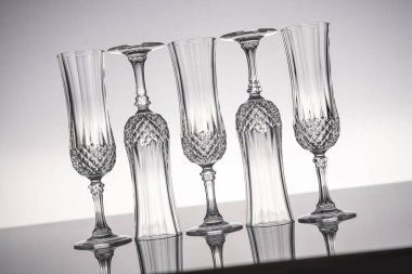 Cam kristal kadehleri kes şampanya flütü, gri arka planlı, parlak gri yüzeyde izole edilmiş..