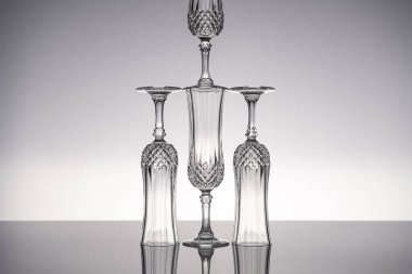 Cam kristal kadehleri kes şampanya flütü, gri arka planlı, parlak gri yüzeyde izole edilmiş..