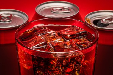 Buzla dolu bir bardak ve kırmızı zemin üzerinde taze soğuk bir kola.