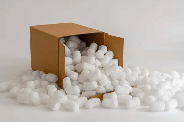包装ピーナッツで満たされた白い背景に隔離された段ボール箱 — ストック写真
