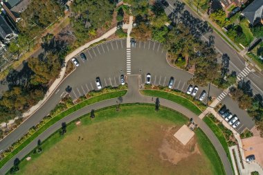 Sydney, Avustralya 'da bir köpek parkının yakınındaki kavisli otopark ve yaya geçitlerini gösteren hava aracı görüntüsü.