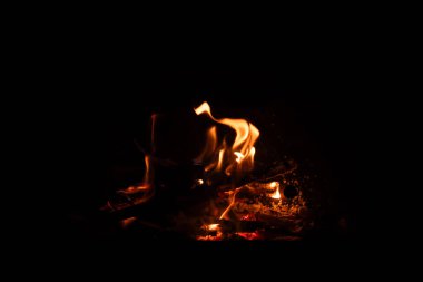 Siyah arka planda yangın alevleri. Geceleri yanan kamp ateşi karanlık arka planda izole edilmiş..