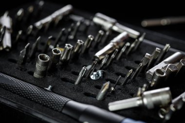 Siyah tepside alüminyum bit sürücüsü olan düzensiz tornavida takımı. Manyetik prizli ve kabzalı sürücü kolu.