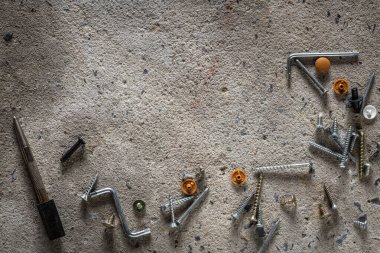 Beton kaplama arka planda vida, tırnak. Kopya alanı olan çimento zemindeki vida ve çivilerin kapatılması.