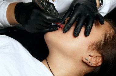 Closeup shot of a lip permanent makeup applying at beauty salon