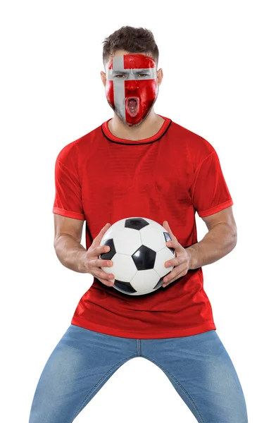 サッカーファンの男とジャージーと顔は白を背景に感情を叫んでデンマークチームの旗で描かれています — ストック写真