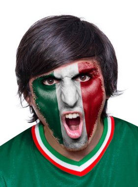 Formalı ve yüzlü futbol taraftarı Meksika takımının bayrağıyla boyanmış beyaz arka planda duygularla bağırıyor..
