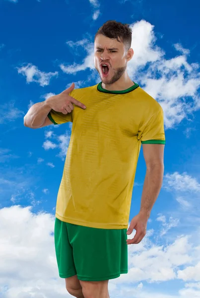 身穿澳大利亚国家队黄色T恤的职业足球运动员兴奋地尖叫着 因为他们在蓝天的背景下 带着蔑视和快乐的表情进球 — 图库照片