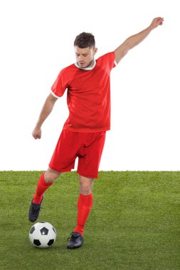 Kırmızı Tunus Milli Takımı formasına sahip profesyonel futbolcu beyaz arka planda meydan okuma ve karar ifadesinde bir gol atmak üzere..