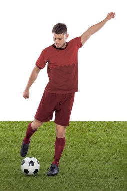 Kırmızı Katar milli takımının formasına sahip profesyonel futbolcu beyaz arka planda meydan okuma ve karar ifadesinde bir gol atmak üzere..