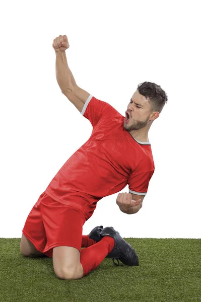 一名职业足球运动员 身穿红色的加拿大国家队球衣 为进球而兴奋地大喊 他在白人背景下表现出挑战和快乐的表情 — 图库照片