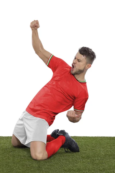 一名职业足球运动员 身穿红色威尔士国家队球衣 为进球而兴奋地大喊 他的进球表现出一种在白人背景下的挑战和快乐 — 图库照片