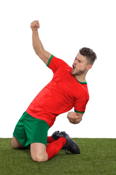 一名职业足球运动员 身穿红色的摩洛哥国家队球衣 为进球而激动地大喊 他的进球在白人背景下表现出挑战和快乐 — 图库照片