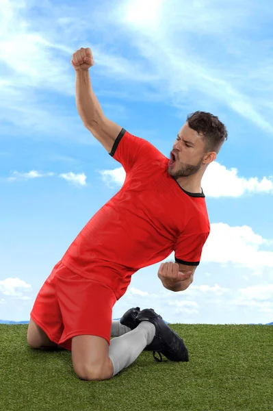 一名职业足球运动员 身穿红色韩国国家足球队球衣 在赛场上用一种挑战和快乐的表情射门 兴奋地大喊 — 图库照片