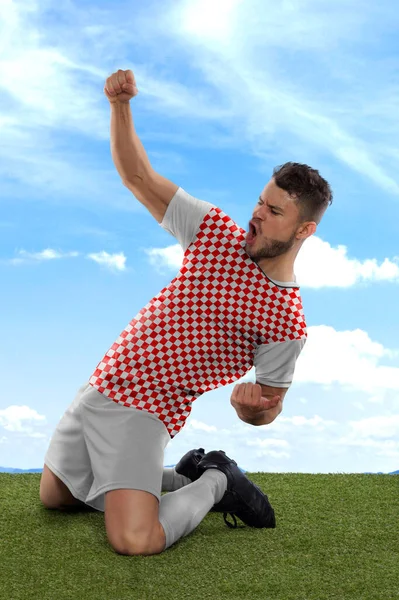 克罗地亚职业足球运动员 红白相间的克罗地亚国家队球衣队员 在赛场上用一种挑战和快乐的表情射门 兴奋地大喊 — 图库照片