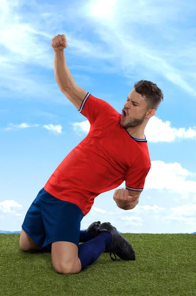 파랑의 스페인 유니폼을 선수가 행복의 잔디와 배경을 표현하며 흥분하며 외치고 — 스톡 사진