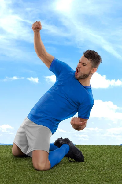 日本职业足球运动员 身穿蓝色国家队球衣 为进球而激动地大喊 在场上的草场和云彩背景下表现出挑战和快乐 — 图库照片