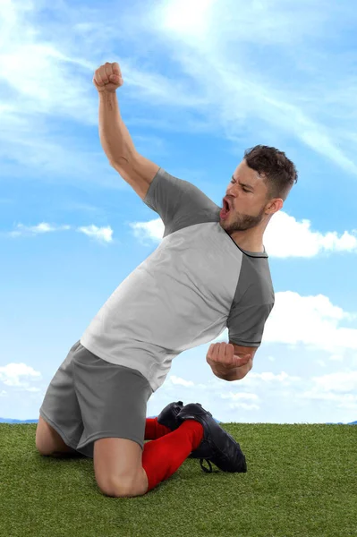 拥有灰色波兰国家队球衣的职业足球运动员兴奋地大喊 因为在球场的草场和云彩背景下 他们的进球充满了挑战和快乐 — 图库照片