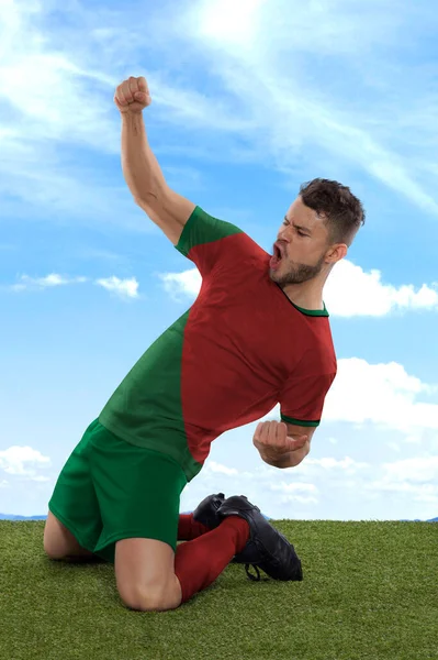职业足球运动员 身穿红白相间的国家队球衣 为进球而激动地大喊 在场上的草场和云彩背景下表现出挑战和快乐 — 图库照片
