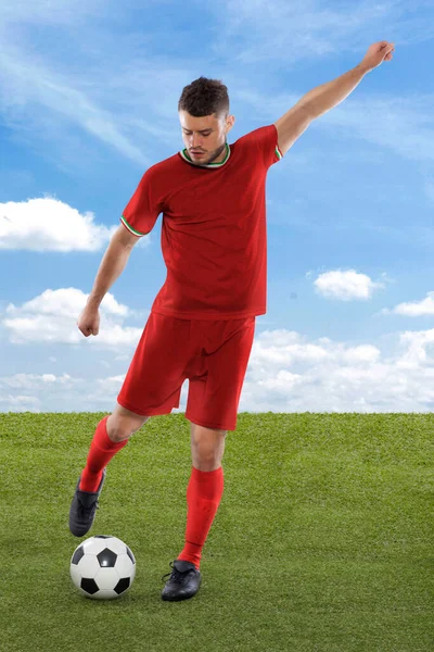 红衣主教红衣主教国家队的职业足球运动员即将进球 在场上的草地和云彩背景下 他的脸上流露出挑战和决断的表情 — 图库照片