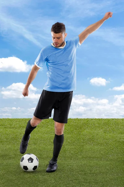 Uruguay Millî Futbol Takımı forması ile profesyonel futbolcu sahadaki çimenler ve bulut arka planında meydan okuma ve karar ifadesiyle gol atmak üzere.