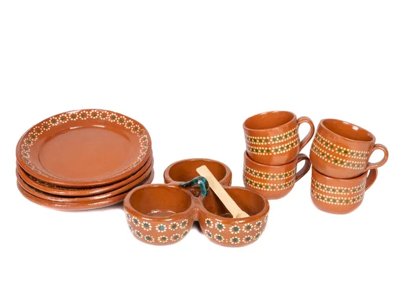 Tableware of several pieces of red clay made in Mexico. Traditional handmade Mexican clay crockery. isolated White background.