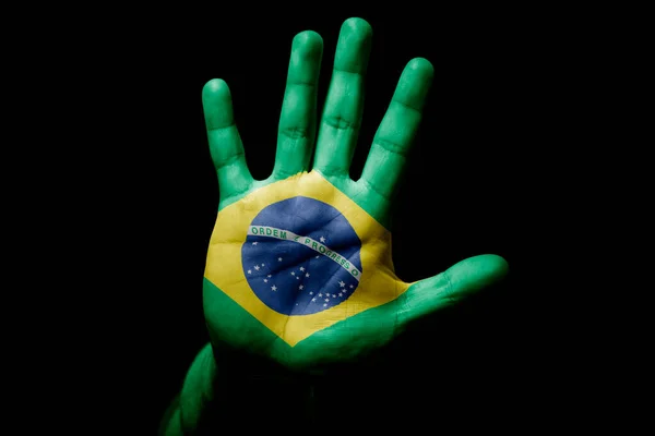 Rude man hand with flag of Brazil in stop sign to anger, discrimination, racism, abuse on black background.