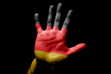 Rude man hand with flag of Germany in stop sign to anger, discrimination, racism, abuse on black background.