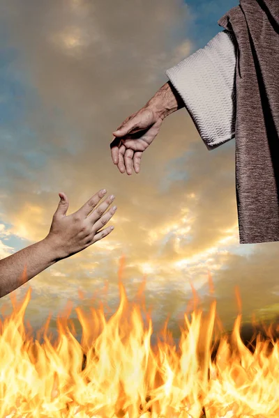 耶稣基督的手帮助别人走出地狱的火焰 大火的背景和多云的天空 — 图库照片