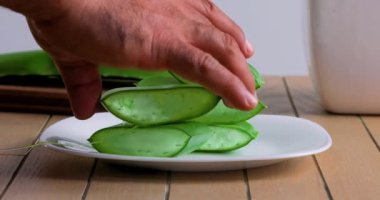  Aloe Vera 'nın tahta kesme tahtasıyla kesilip suda yıkandığını gösteren bir video.