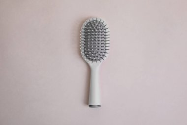 Bej arka planda gri detaylar içeren gri plastik tarak