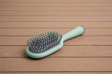 ahşap bir arka planda gri detaylarla tutacağı olan aquamarine plastik tarak