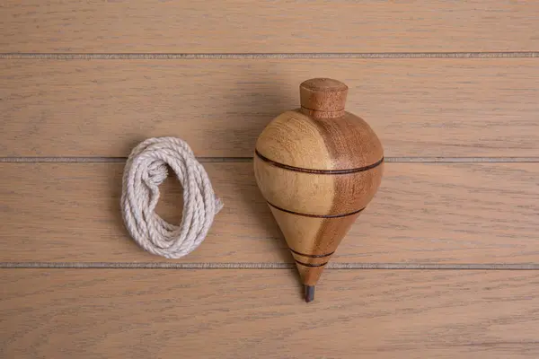 stock image Wooden trompo, Mexican handmade toy made of natural mesquite with rope on wooden table