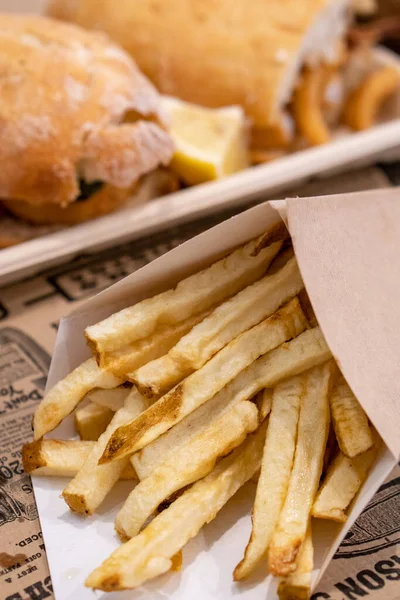 Patates kızartmasının karton bir külahta yakın plan fotoğrafı. Yemek ve fast food konsepti.