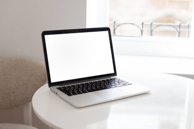 Laptop beyaz bir ekranla masada. dizaynınız için yer