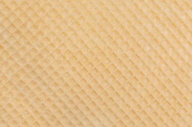 The texture of a brittle, beige waffle close-up. Material for cakes and pastries. Place for your design