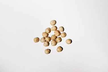 Close-up of peeled blanched hazelnuts illuminated by hard light on a white isolated background. Cosmetic ingredient and image for your design