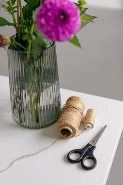 Brązowa Uprząż Nożyczki Różowe Kwiaty Tworzenia Bukietu Białym Stole Pionowy — Zdjęcie stockowe