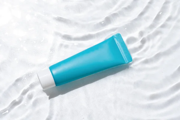 stock image Blue moisturizer tube mockup close-up on white isolated background with water waves. Image for your design