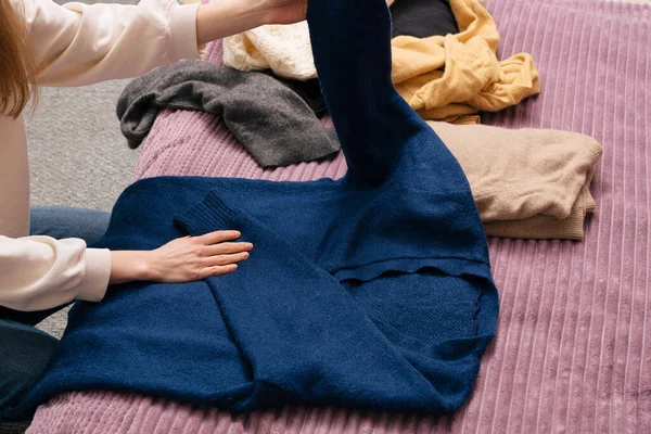 Young Woman Folds Warm Winter Blue Sweater Storage Concept Updating — Stock Photo, Image