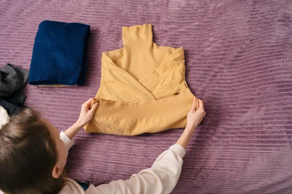Young Woman Neatly Folds Yellow Warm Sweater Seasonal Storage Organization — Stock Photo, Image