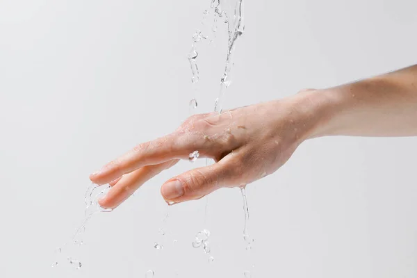 灰色の隔離された背景に女性の手に注ぐ水 肌の水分補給と水分補給 アンチエイジングケアの概念 デザインのイメージ — ストック写真