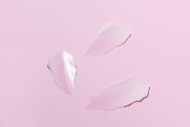 Pembe izole arka planda beyaz yüz kremi örneği ya da lekesi. Cilt bakımı, güneş koruması ve nemlendirici güzellik ürünleri kavramı