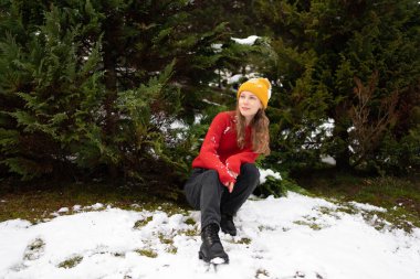 Noel ağaçlarının arkasında kartopu oynadıktan sonra dinlenen genç ve çekici bir kadının portresi..